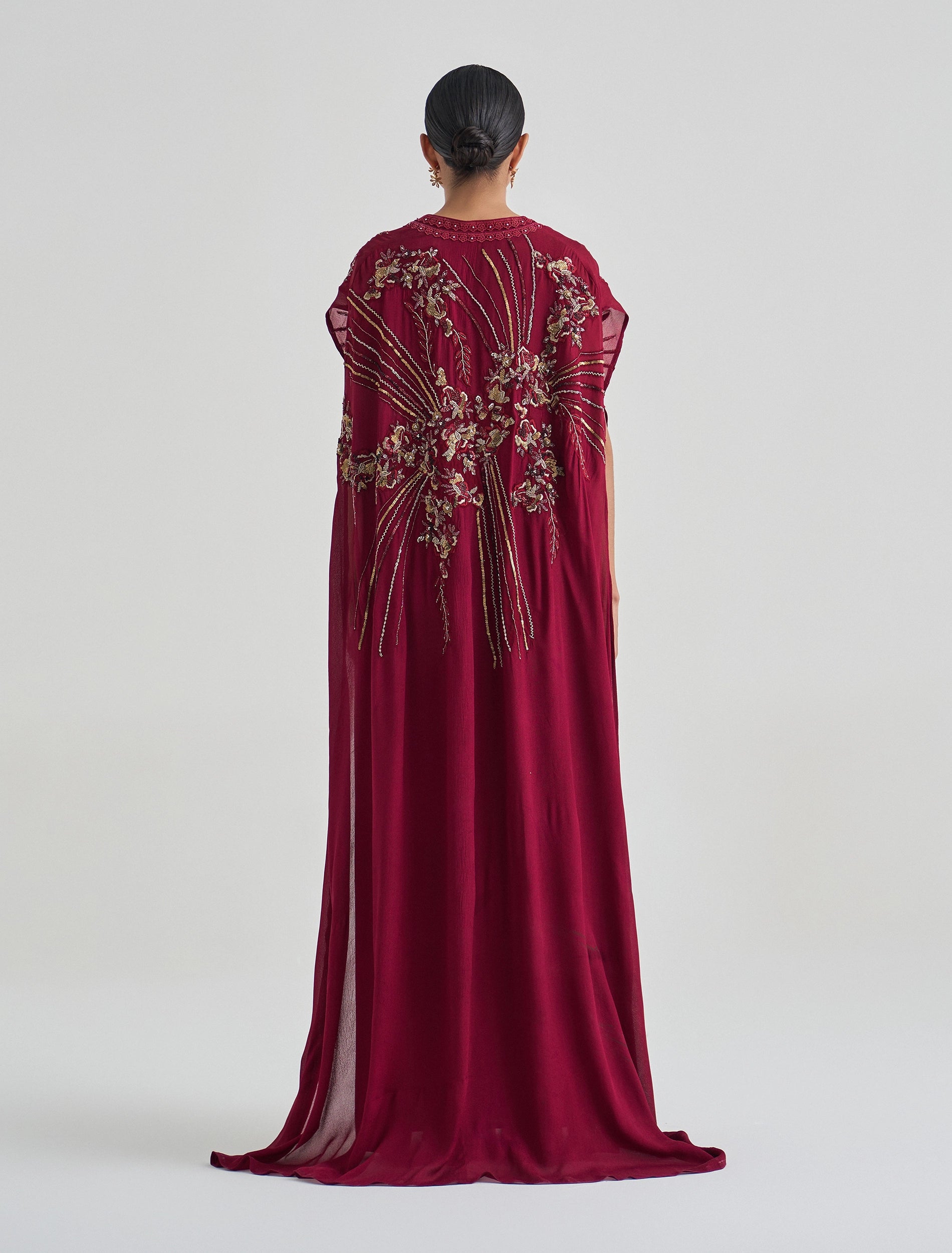 Long burgundy dress with gold embroidery and a cape